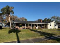 Brick ranch house with covered porch, large yard, and waterfront views at 1401 Lake Shore Blvd, Tavares, FL 32778