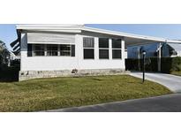 White single-wide manufactured home with carport and landscaped lawn at 1401 W Highway 50 # 89, Clermont, FL 34711