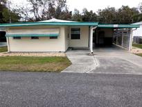 Front view of a single story home with carport at 164 Jacaranda Dr, Leesburg, FL 34748