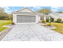 Charming single-story home featuring a patterned driveway, neutral siding, and attached garage at 2123 Barbosa Ct, The Villages, FL 32159