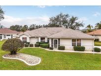 Charming single-story home featuring a well-manicured lawn, tasteful landscaping, and neutral exterior paint at 21721 Loch Haven Pass, Leesburg, FL 34748