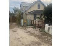 Charming yellow house with metal roof, and a small front yard at 2315 Thelma Ave, Haines City, FL 33844