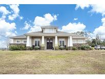 Single-story home with stone accents and a large front porch at 41516 Saddle Ridge Ln, Weirsdale, FL 32195