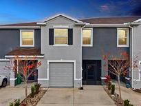 Charming two-story townhome featuring a gray exterior, attached garage, and well-maintained landscaping at 5278 Dragonfly Dr, Wildwood, FL 34785