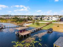 Beautiful aerial view showcasing a dock, boat lift, and waterfront access to a lake with lily pads at 16428 Good Hearth Blvd, Clermont, FL 34711