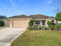 Single-story home with two-car garage and landscaped front yard at 3074 Salerno Ln, The Villages, FL 32163