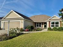 Inviting single-story home boasts a well-maintained lawn, landscaped garden, and a neutral color palette at 3554 Oracle Ct, The Villages, FL 32163