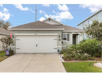 Charming single-Gathering home featuring a two-car garage, landscaped yard, and neutral paint scheme at 707 Chinoy Rd, Davenport, FL 33837