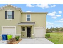 Two-story townhome with attached garage and landscaping at 961 Lido Dr, Howey In The Hills, FL 34737