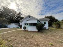 Charming white house with green accents, detached garage, and spacious yard at 13920 S Highway 25, Eastlake Weir, FL 32133