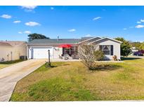 Single story home with attached garage and landscaped yard at 1842 Captiva Ct, The Villages, FL 32162