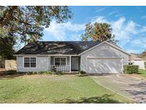 Gray house with a two-car garage and a well-maintained lawn at 2121 Croat St, Mount Dora, FL 32757