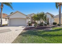 Single-story home with attached garage and landscaped yard at 2134 Zaragoza Pl, Lady Lake, FL 32159