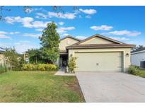 Charming one-story house with light green exterior, attached garage, and well-manicured lawn at 2334 Bexley Dr, Tavares, FL 32778