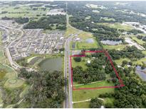 Aerial view of property showing home, land, and surrounding area at 3704 Warm Springs Ave, Wildwood, FL 34785