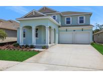 Charming two-story home features a two-car garage and landscaped front yard, creating appealing curb appeal at 5155 Firebush Dr, Apopka, FL 32712