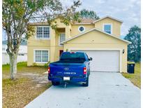 Two-story house with a two-car garage and a paved driveway at 762 Squirrel Ct, Kissimmee, FL 34759