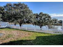 Backyard with white vinyl fence, overlooking a lake at 8480 Se 167Th Forsyth St, The Villages, FL 32162