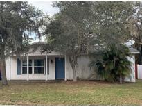 One-story house with a covered porch, blue door, and mature landscaping at 1006 Idaho Ct, Ocoee, FL 34761