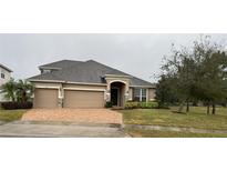 Two-story house with three-car garage and landscaped lawn at 1350 Cavender Creek Rd, Minneola, FL 34715