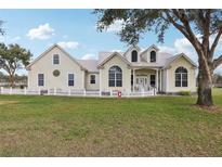 Charming home featuring a metal roof, dormer windows, and a white picket fence at 13718 County Road 450, Umatilla, FL 32784