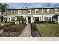 Two-story townhome with gray siding, brown shutters, and a brick walkway at 16929 Tesla Aly, Winter Garden, FL 34787