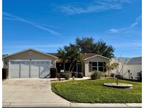 Single-story house with a two-car garage and well-maintained lawn at 17483 Se 74Th Netherclift Ter, The Villages, FL 32162