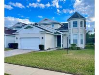 Two-story house with a two-car garage, and a well-maintained lawn at 2185 Victoria Dr, Davenport, FL 33837