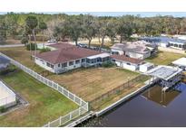 Aerial view of single-story home with canal access and fenced backyard at 28228 Tammi Dr, Tavares, FL 32778