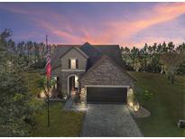 Two-story home with stone accents and a three-car garage at 9277 Sw 70Th Loop, Ocala, FL 34481