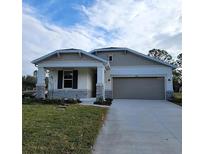 One-story home with gray siding, stone accents, and a two-car garage at 10161 Spring Lake Dr, Clermont, FL 34711