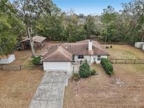 Aerial view of a single story house with a fenced yard and detached shed at 15831 Se 89Th Ter, Summerfield, FL 34491