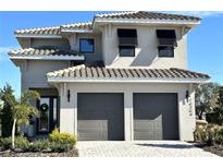 Two-story home with gray exterior, two-car garage, and landscaping at 16254 Ravenna Ct, Bella Collina, FL 34756