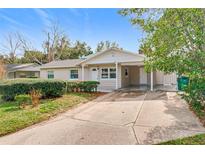 Tan house with carport, landscaping, and a spacious front yard at 1805 Jefferson Dr, Mount Dora, FL 32757