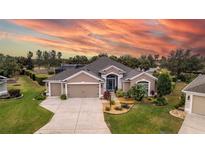 Charming single Gathering home with a well-manicured lawn, mature trees, and a spacious three car garage at 3257 Triton Ct, The Villages, FL 32163