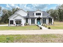 Two-story modern farmhouse with black windows, light-colored siding, and landscaped yard at 3493 Edwards Road, Lady Lake, FL 32159