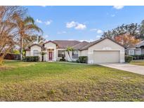 Single-story home with attached garage and well-maintained lawn at 36341 Grand Island Oaks Cir, Grand Island, FL 32735