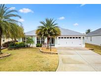 Single-story house with a white garage door and palm trees in the front yard at 3962 Neighborly Way, The Villages, FL 32163