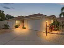 Well-maintained villa with a landscaped front yard, driveway, and garage at 419 Cambio Ct, The Villages, FL 32159