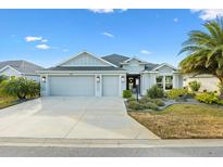 Two-story house with a three-car garage and landscaped front yard at 5676 Patterson Loop, The Villages, FL 32163