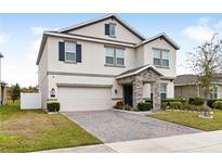 Two-story house with a stone accent and a two-car garage at 848 Carmillion Ct, Groveland, FL 34736