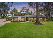 Inviting home exterior with stone accents and a lush lawn at 9605 Hollyglen Pl, Windermere, FL 34786