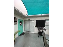 Inviting condo exterior, featuring a teal door and shaded patio at 1017 Willow Dr, Leesburg, FL 34748