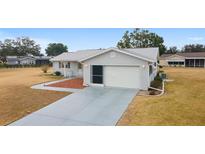 Single story home with attached garage and landscaped yard at 10476 Se 178Th St, Summerfield, FL 34491