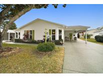 White single story home with green accents and carport at 1220 Maria Ct, Lady Lake, FL 32159