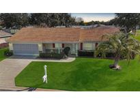 Single-story home with a brown roof, attached garage, and landscaped lawn at 13709 Se 89Th Ave, Summerfield, FL 34491