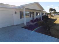 White single story home with carport and landscaped yard at 17664 Se 105Th Terrace, Summerfield, FL 34491