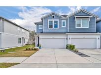 Two-story townhome with gray siding, two-car garage, and landscaping at 1819 Terrapin Rd, Ocoee, FL 34761