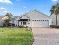 One-story house with a two-car garage and well-maintained lawn at 2005 Palo Alto Ave, Lady Lake, FL 32159