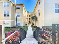 Inviting walkway to condo building with landscaping and exterior architectural details at 413 Summit Ridge Pl # 201, Longwood, FL 32779
